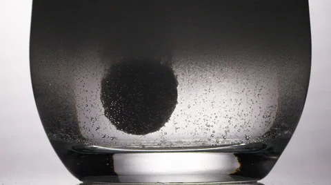Close up of tablet dissolving in glass of water, in slow motion Stock Footage 57485080