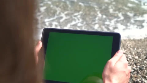 Close-up Of A Tablet With A Green Screen In The Hands Of A Girl On The Seashore. Stock Footage 170477260