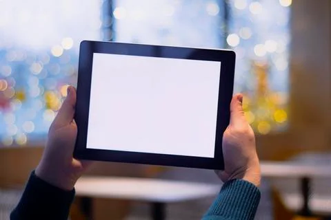 Close-up Tablet mockup with white screen. A male freelancer works in a cafe. Stock Photos
