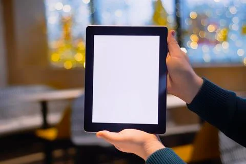 Close-up Tablet mockup with white screen. A male freelancer works in a cafe. Stock Photos