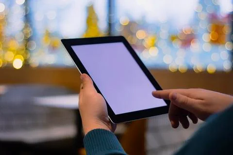 Close-up Tablet mockup with white screen. A male freelancer works in a cafe. Stock Photos