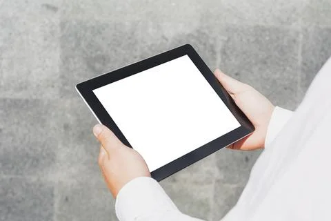 Close-up tablet mockup with a white screen in the hands of a businessman agai Stock Photos