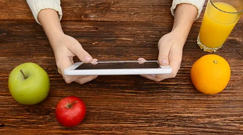 Close up of tablet pc screen with fruits and orange juice on the table. Video stock 56891786
