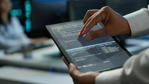 Close up of tablet used by IT worker doing maintenance on server farm gear Stock Photos