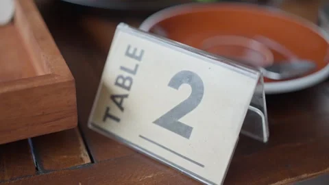 Close up. A tabletop sign displaying the number 2 at a cafe. Slow motion 库存影片 252887581