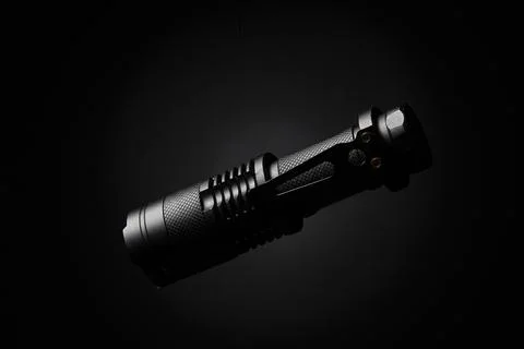 Close-up of a tactical LED flashlight on black background with professional.. 写真素材