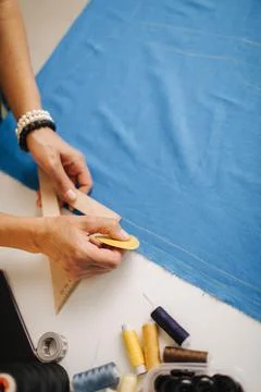Close up of tailor drawing lines with soap on blue cloth Stock Photos