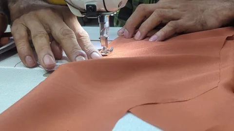 Close Up of Tailor Hands Sewing Brown Leather Fabric with Industrial Machine Stock Footage 328973230