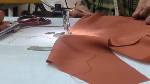 Close Up of Tailor Hands Sewing Brown Leather Fabric with Industrial Machine Stock Footage 328973264