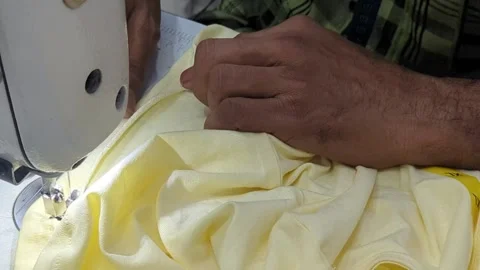 Close-up of Tailor Hands Sewing Yellow Fabric on Professional Machine Stock Footage 333204258