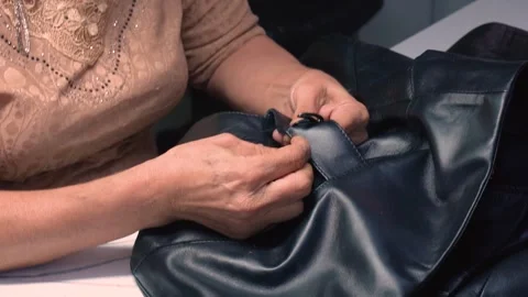Close-Up of Tailor Sewing Generic Patch on Leather Jacket in Slow Motion Stock Footage 322056921