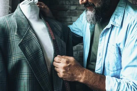 Close up of tailor at work in the workshop taking measures of an elegant suit 스톡 사진