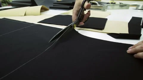 Close-up of a tailor's hands cutting fabric with scissors Stock Footage 259613601