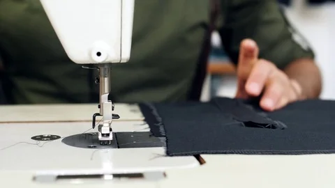 Close-up of tailor's hands sewing on the sewing machine. Stock Footage 80730307