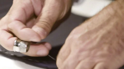 Close up of a tailor's hands using a thimble. Tailor's tacks, basic sewing Stock Footage 127040028