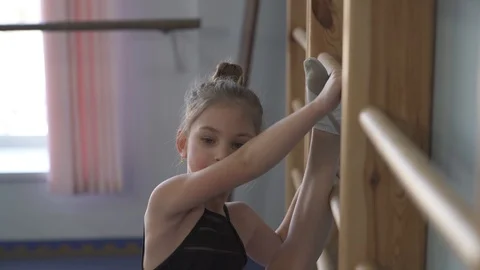 A close-up of a talented young athlete doing gymnastic exercises on wall bars 動画素材 105473989