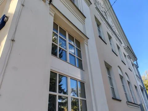 A close-up of tall rectangular windows on a beige neoclassical facade with Stock Photos
