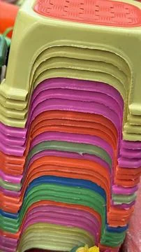 A close up of a tall stack of brightly colored plastic stools. Stock Photos