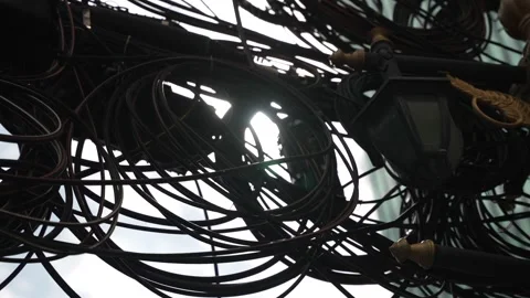 Close-up of tangled electrical and communication wires on a street in Bangkok Stock Footage 310756974