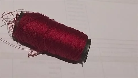 Close Up of Tangled Red Thread Bobbin for Tailoring Work Stock Footage 296978474