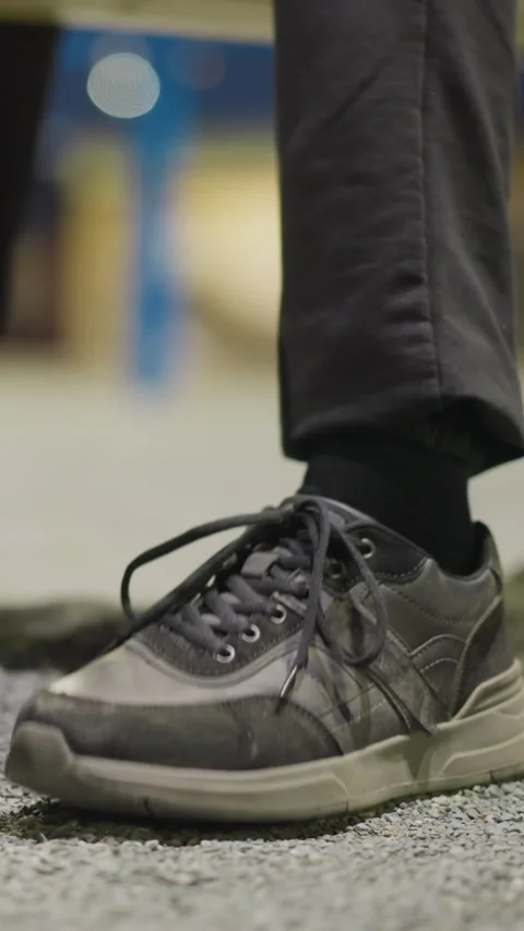 Close-Up of Tapping Foot with Blurred Background in Dim Lighting Vídeo Stock 317567747