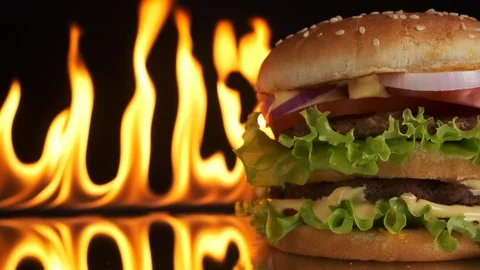 Close-up of tasty, appetizing, meat burger, a blazing fire in the background. Vídeos de archivo 125637492