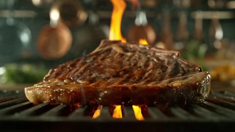 Close-up of tasty raw beef steak on cast-iron grate with fire flames Stock Footage 270093149