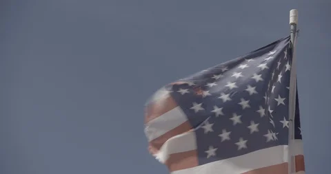 Close Up Tattered American Flag Waving Against Blue Sky - Tilt Down Stock Footage 89943062