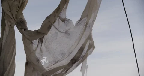Close Up of Tattered Curtains Blowing in Wind Tilt Down Stock Footage 89943218