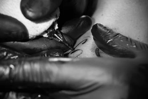 Close up of a tattoer's tattoo machine while makes a tattoo Stockfoto's