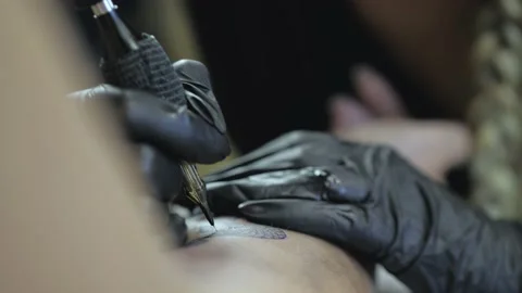 Close-up. tattoo artist makes a snake tattoo on the wrist. tattoo parlor. tat Stock Footage 139085053