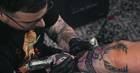 Close up tattoo artist shows the process of getting tattoos with paint. Stock Footage 236348826