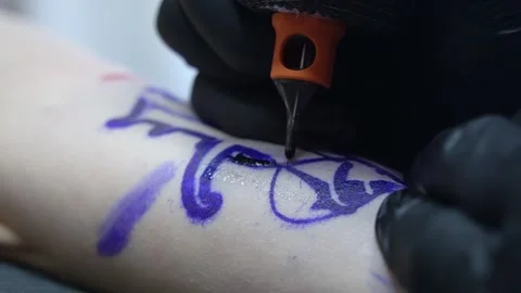 Close-up of a tattoo machine needle with white paint paints the skin. Close-up Stock Footage 277113004