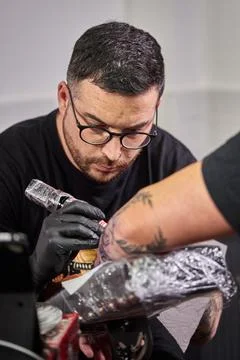 Close the tattoo machine. Tattoo image on arm by a professional tattoo artist Stock Photos