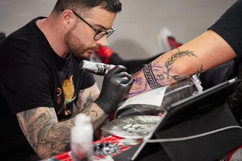 Close the tattoo machine. Tattoo image on arm by a professional tattoo artist Stock Photos