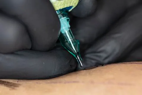 Close-up on the tattoo machine while doing a tattoo Stock Photos