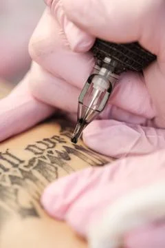 Close-up of a tattoo needle. The process of the tattoo master. Pink women's Stock Photos