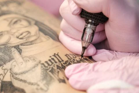 Close-up of a tattoo needle. The process of the tattoo master. Pink women's Foto stock