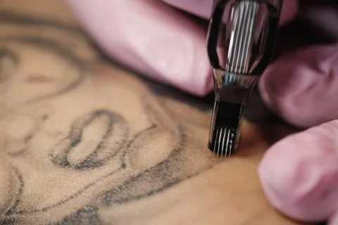 Close-up of a tattoo needle. The process of the tattoo master. Pink women's Stock Photos