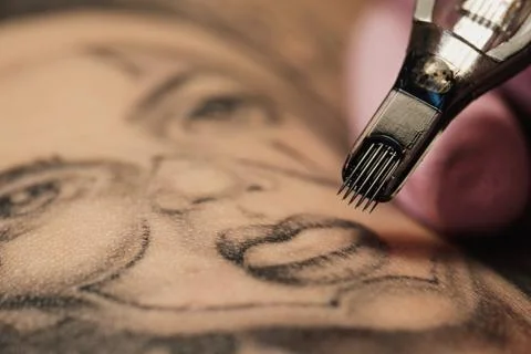Close-up of a tattoo needle. The process of the tattoo master. Pink women's Foto stock