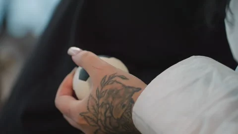 Close up of tattooed hand with wound squeezing stress ball in emotional moment Stock Footage 310142152