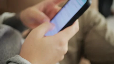 Close-up of tattooed hands typing and texting on a smartphone... Stock Footage 318177971