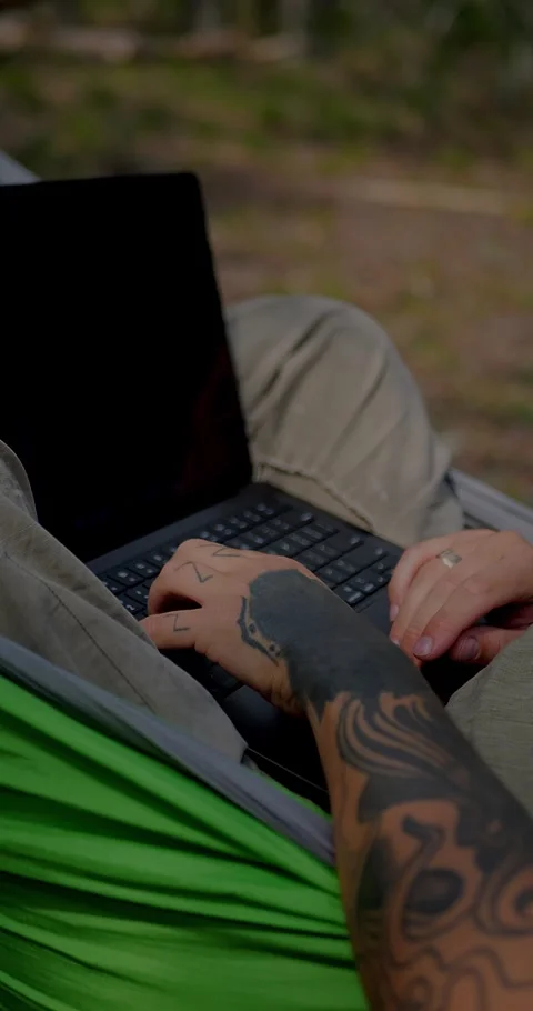 Close-Up Of Tattooed Hands Typing On A Laptop... Stock Footage 331820830