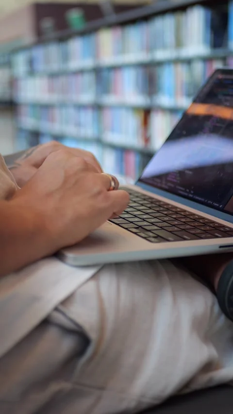 Close-Up of Tattooed Hands Typing on Laptop Indoors, Illustrating Remote Work... Vídeo Stock 334437316