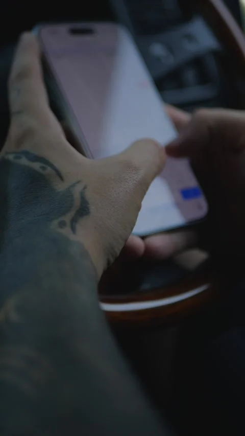 Close-up of tattooed hands using a smartphone inside... Vidéo 341613208