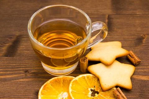 Close-up of tea and biscuits with orange and cinnamon on wooden table Stock Photos