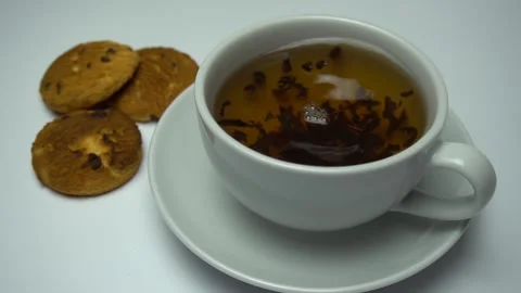 Close up of tea being rotating into cup with cookies. Zoom in Stock Footage 85643001