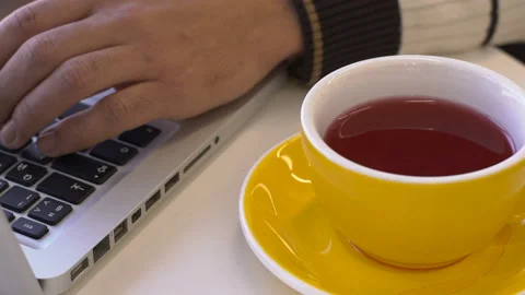 Close up of tea cup and laptop on the table in cafe. Stock Footage 85621046