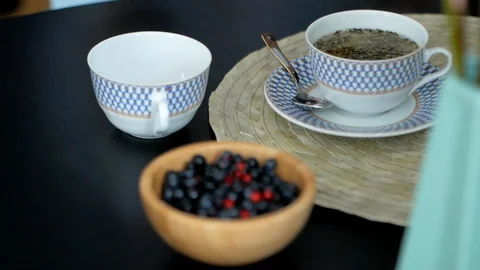 Close up tea cup on wood table with tea leaves. Stock Footage
