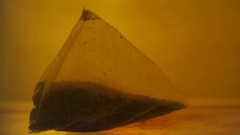 Close-up of a tea pack brewing in hot water. Natural black tea making process. Stock Footage 116861309